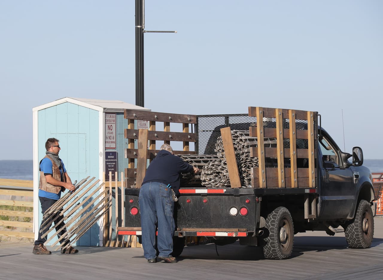 Los empleados de la ciudad trabajan en el malecón de Long Beach a pocas horas de su reapertura, en la madrugada del 21 de mayo.