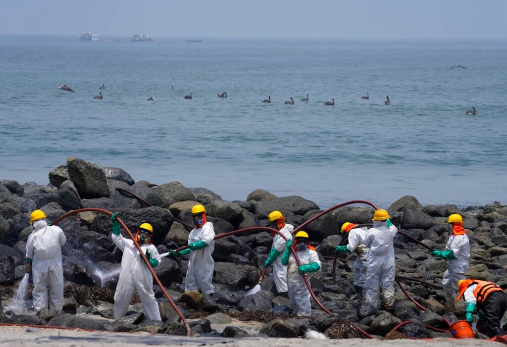Equipos de limpieza trabajan en la playa de Pocitos contaminada por un derrame de petróleo, en Ancón, Perú, el 15 de febrero de 2022.