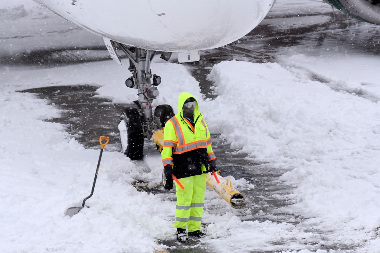 Los equipos de tierra eliminan la nieve del asfalto del aeropuerto a medida que los vuelos se reanudan después de una nevada durante la noche, en el Aeropuerto Internacional de Albany en Colonie, Nueva York.
