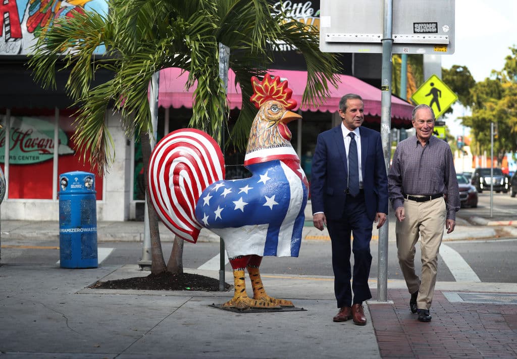 El exalcalde de Miami Manny Díaz y el candidato presidencial demócrata y exalcalde de la ciudad de Nueva York, Mike Bloomberg, caminan por el barrio de La Pequeña Habana el 3 de marzo de 2020 en Miami, Florida.