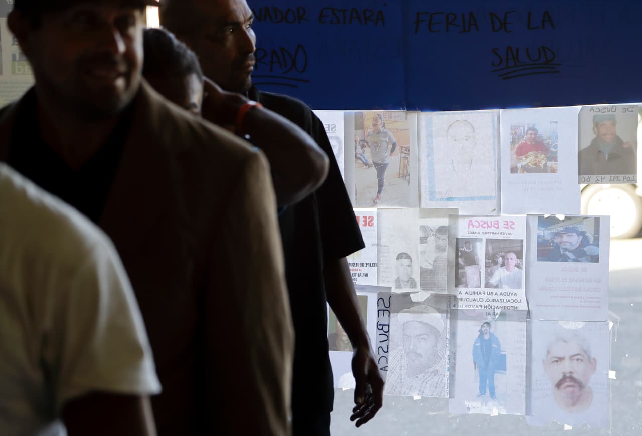 Hombres hacen fila para comer mientras carteles con la imagen de desaparecidos cubren una ventana en un albergue para migrantes en Tijuana, México. En todo el mundo la gente escapa de las guerras, el hambre y el desempleo, y las migraciones mundiales han alcanzado niveles sin precedentes, llegando a 258 millones de migrantes en el 2017. Eso representa un aumento del 49% respecto a comienzos del siglo, según Naciones Unidas. (AP Foto/Gregory Bull)