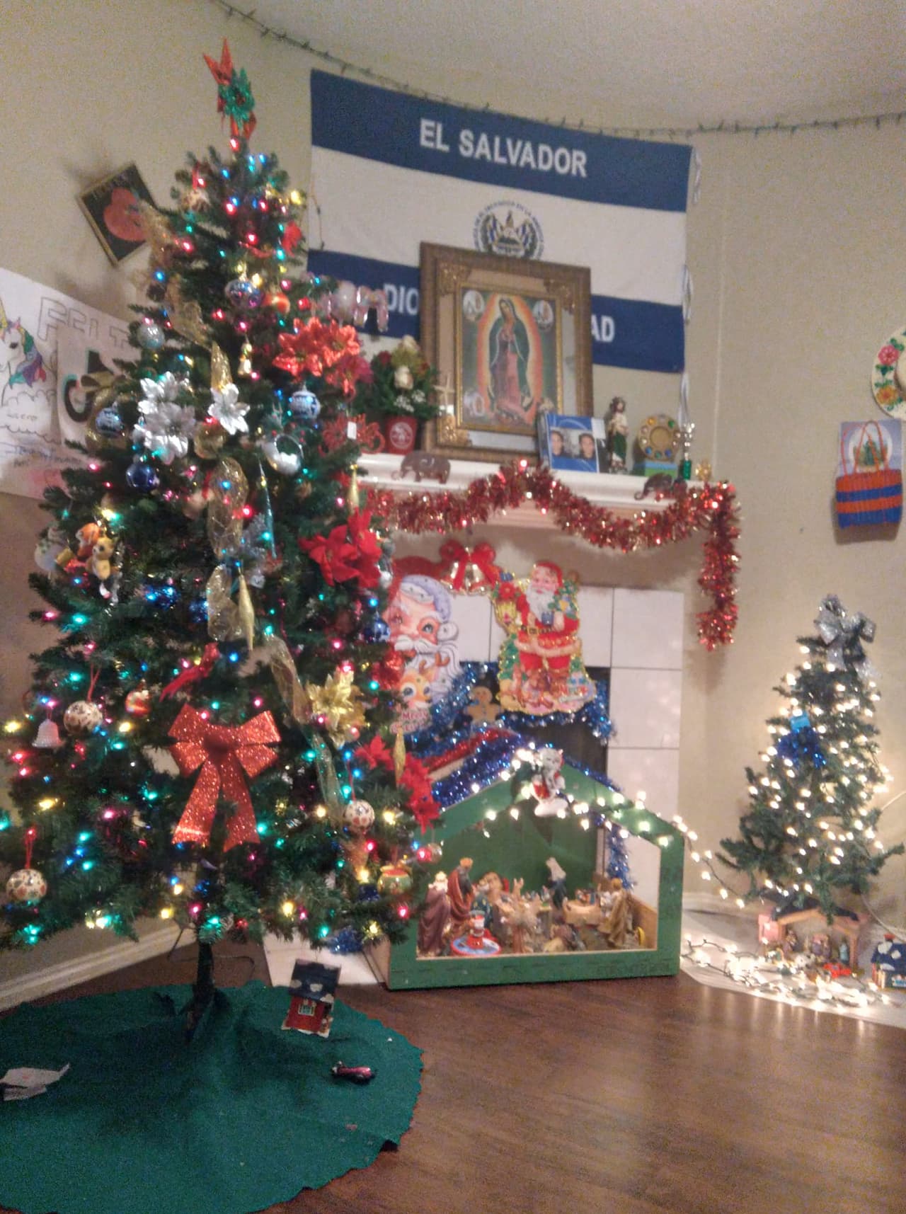 Abigail Claros nos envía esta fotografía de su árbol navideño con la bandera de El Salvador y la Virgen de Guadalupe de fondo.
