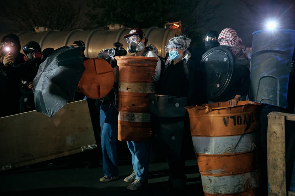 Hubo manifestantes que no solo llegaron con máscaras para protegerse del gas pimienta; también utilizaron los botes naranjas de tránsito como barricadas.
