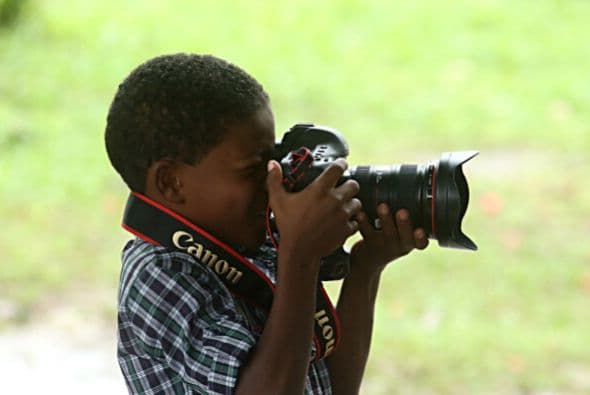 Un pequeño toma una fotografía en un centro de caridad cuando la selección alemana llegó de sorpresa.