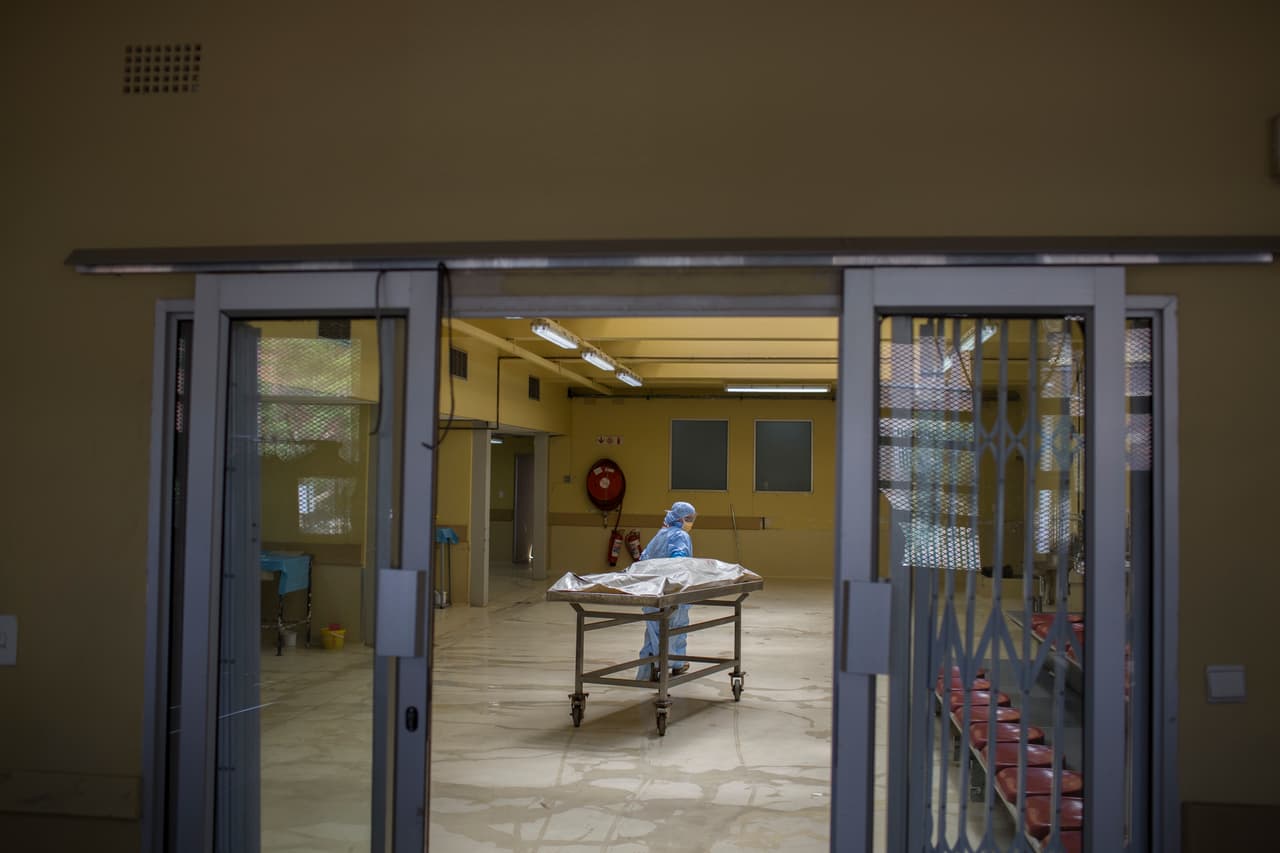 Un forense transporta un cuerpo en un depósito de cadáveres en el vecindario de Hillbrow en Johannesburgo. Cuando los inmigrantes indocumentados mueren y nadie reclama su cuerpo, no hay ningún registro de ellos a nivel nacional o internacional. (Foto AP / Bram Janssen)