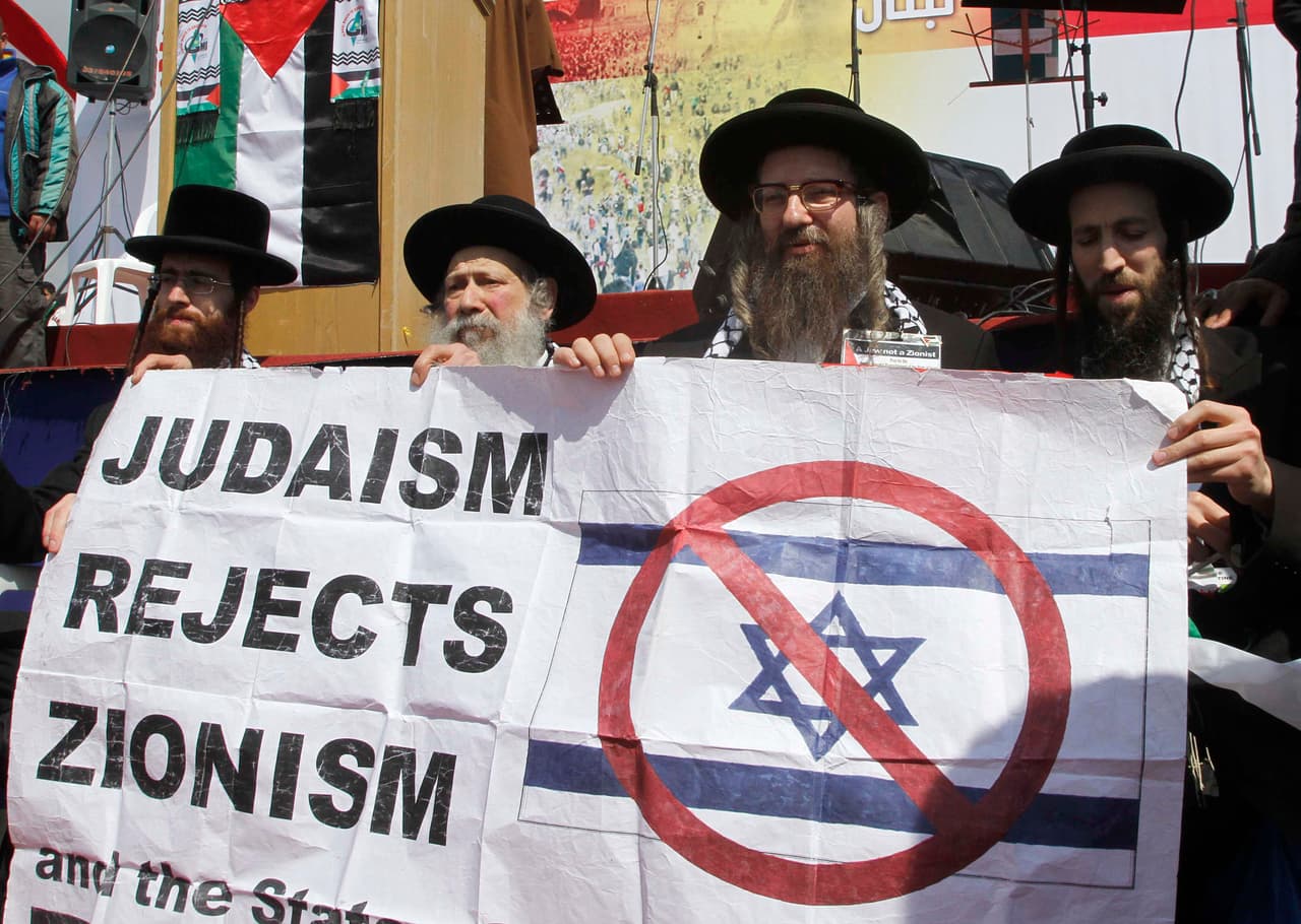 Miembros del grupo judío ultraortodoxo Neturei Karta sostienen una pancarta que dice "El judaísmo rechaza el sionismo", en una manifestación en el sur del Líbano.