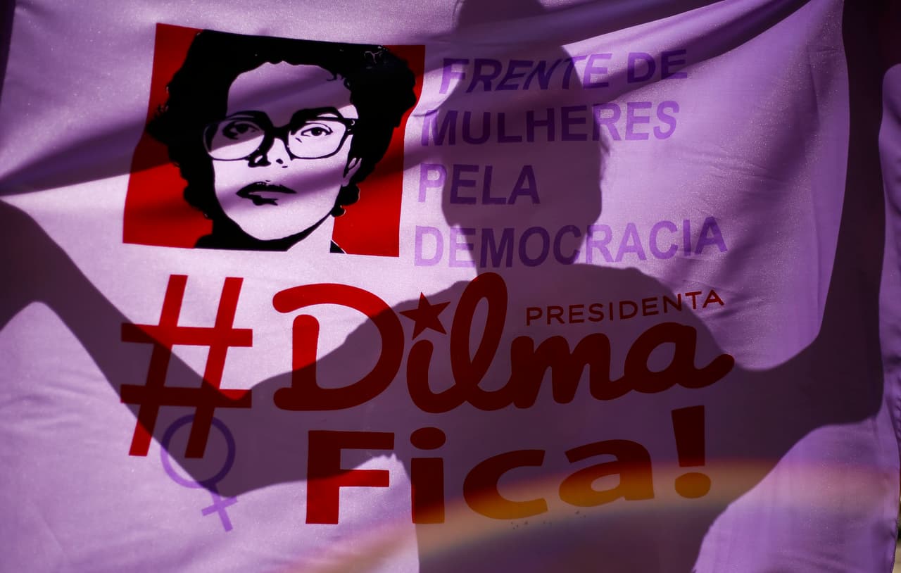 La sombra de un partidario de Dilma Rousseff en una bandera en donde está escrito "Dilma se queda", en una manifestación a favor de la presidenta en San Pablo, el 17 de abril de 2016