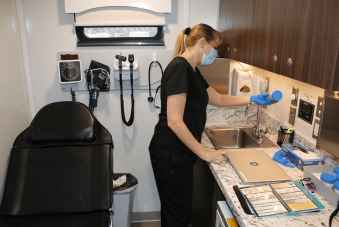 La enfermera Christi Couron prepara muestras de orina en la clínica móvil de tratamiento de adicciones para enviarlas al laboratorio. Las tiras reactivas en el vaso de muestras dan una evaluación temprana al detectar instantáneamente 13 categorías de drogas, desde opioides hasta antidepresivos. Los pacientes que visitan la clínica sobre ruedas también pueden conectarse vía telemedicina con proveedores médicos que pueden recetar medicamentos para combatir la adicción. 
<br>