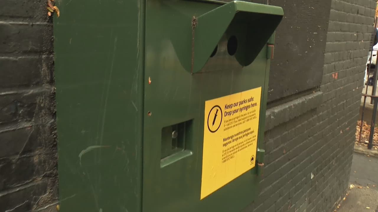 Contenedores de jeringas usadas. "Mantén nuestros parque seguros. Pon tu jeringa aquí", dice el cartel.