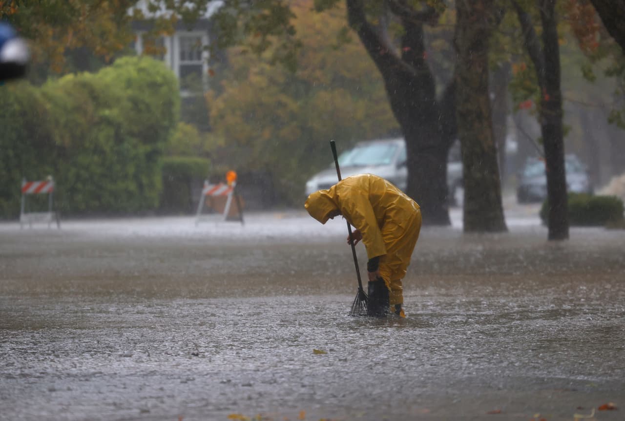 <b>San Rafael. </b>Un trabajador intenta limpiar un desagüe en una calle inundada.