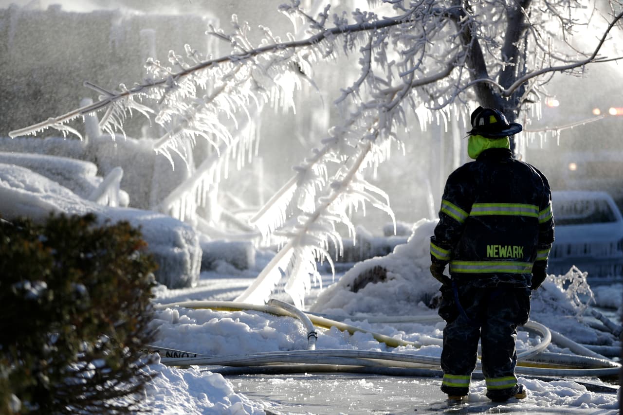 Un bombero entre el hielo, luego de luchar contra un incendio en Newark, Nueva Jersey.