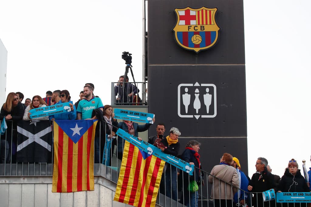 La gente acude al Camp Nou con las cartulinas de 'Spain, sit and talk' y banderas esteladas, de forma pacífica.