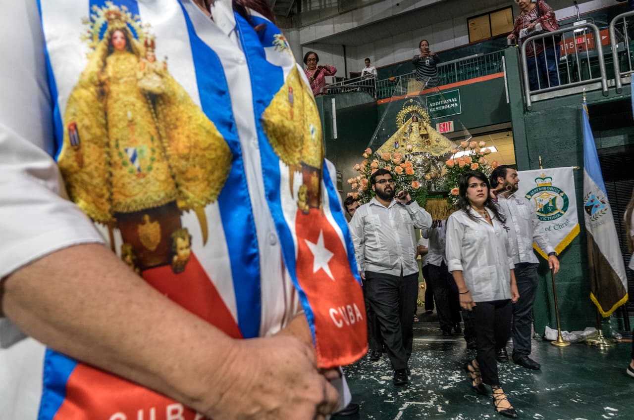 Varias personas portan una imagen de la Virgen de la Caridad del Cobre, patrona de Cuba, antes del oficio de una misa en el Watsco Center de Miami, Florida.