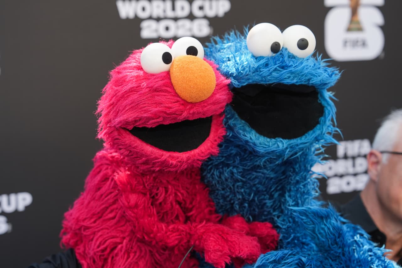 Los titiriteros que manejan a los personajes Elmo y el Monstruo de las Galletas, de *Sesame Street* (Plaza Sésamo), llegan a la alfombra roja. (Foto AP/Jae C. Hong)