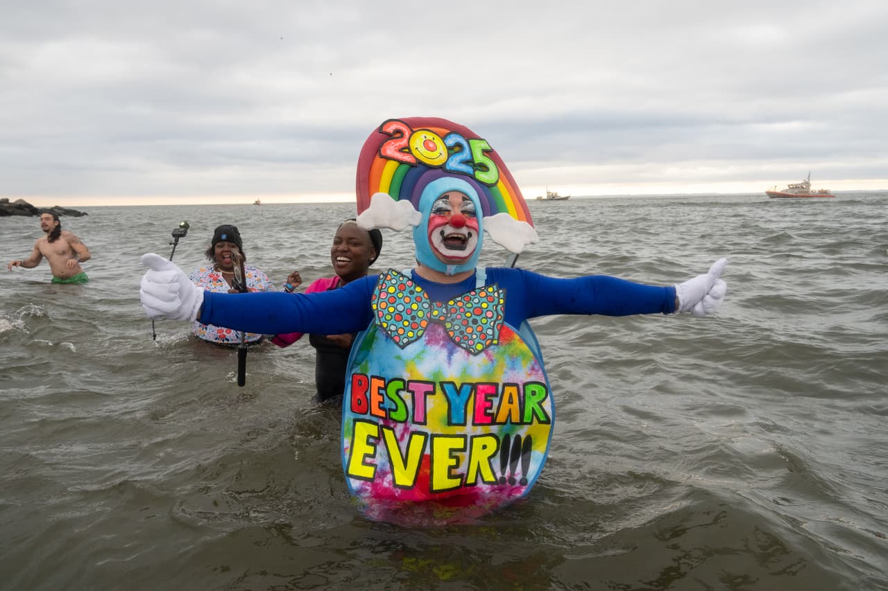 Los participantes, vestidos con trajes de baño, disfraces temáticos y accesorios festivos, crearon un espectáculo colorido que contrastaba con el gris invernal del cielo neoyorquino.