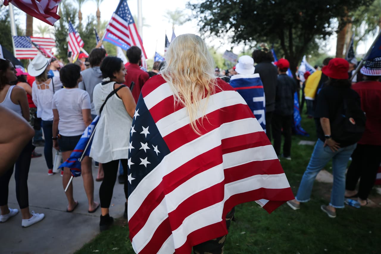 Una mujer envuelta en una bandera de EEUU protesta en Phoenix, Arizona, donde desde el 3 de noviembre lidera los resultados el presidente electo, Joe Biden.