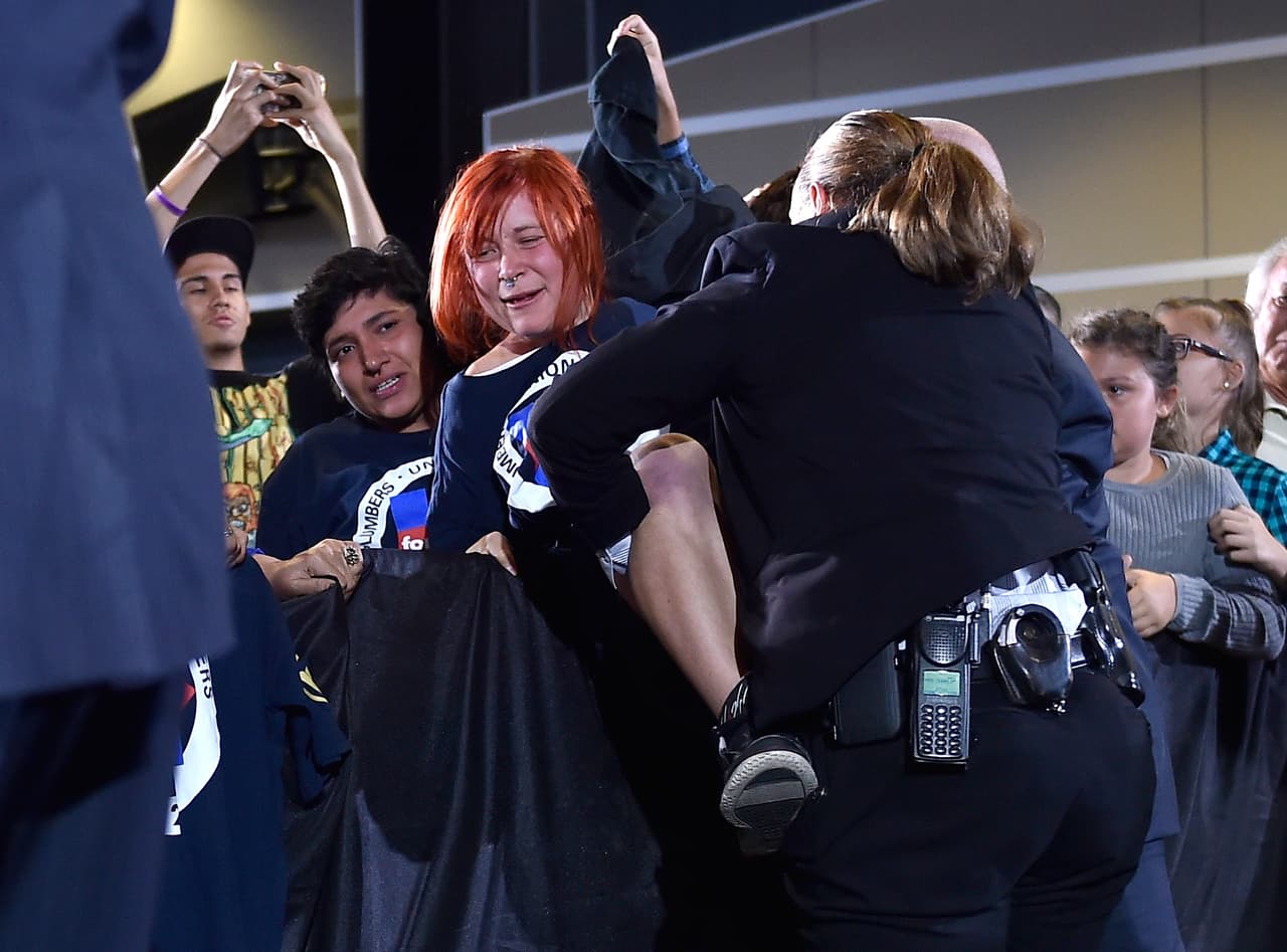 Una manifestante a favor de los derechos de los animales es controlada por los agentes del servicio secreto mientras la candidata demócrata Hillary Clinton habla en un mitín en Las Vegas el 4 de agosto de 2016.