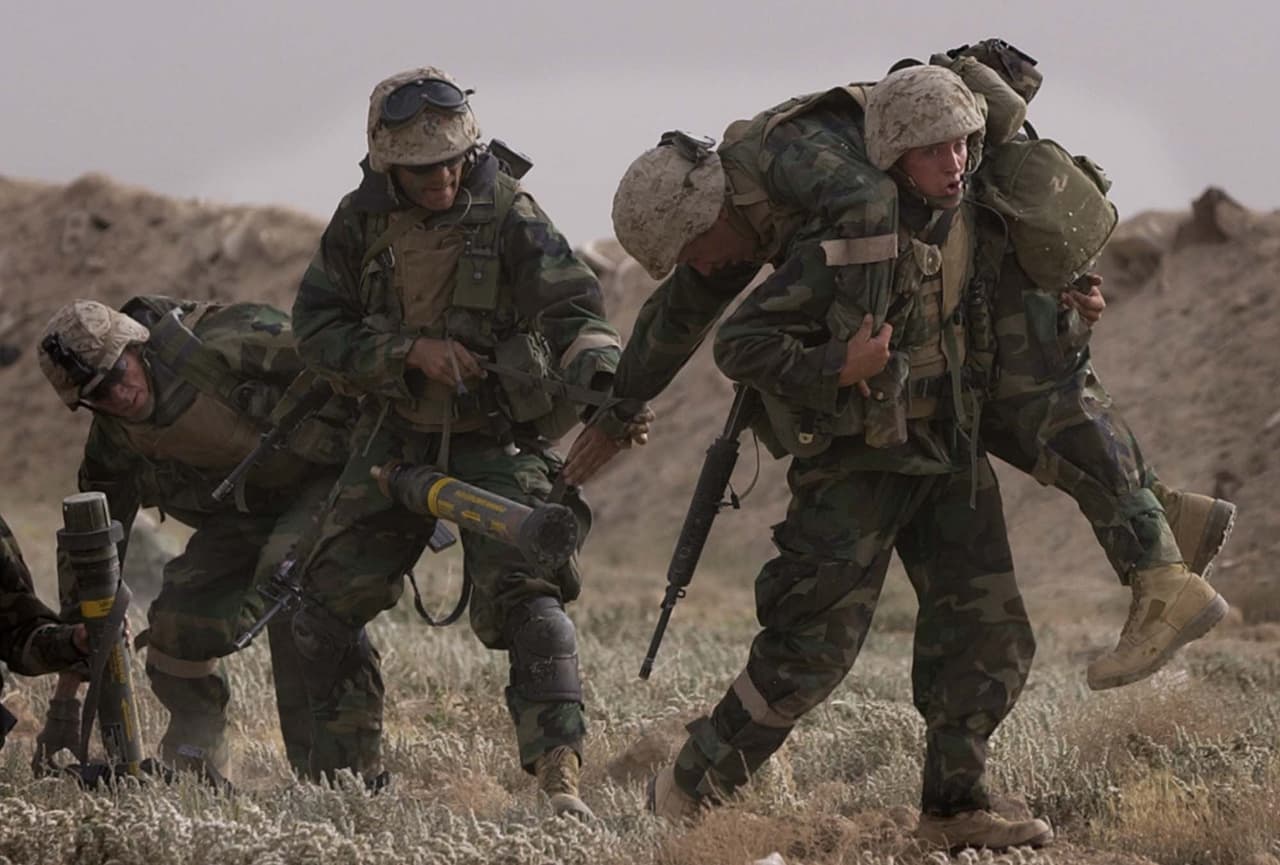 La invasión fue justificada por los informes de inteligencia que aseguraban que el régimen de Hussein fabricaba ilegalmente armas de destrucción masiva. En la fotografía, un soldado estadounidense herido es rescatado por sus compañeros durante un combate con fuerzas leales al líder iraquí en camino a Bagdad el 21 de marzo de 2003.