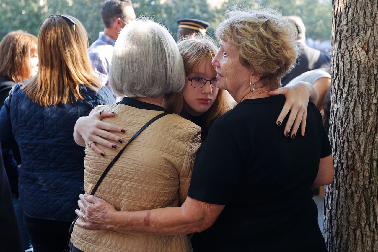 La gente se abraza durante una ceremonia en el Museo y Monumento Nacional del 11 de septiembre, un lugar que para muchos se ha convertido en un cementerio donde ir a recordar a sus seres queridos.