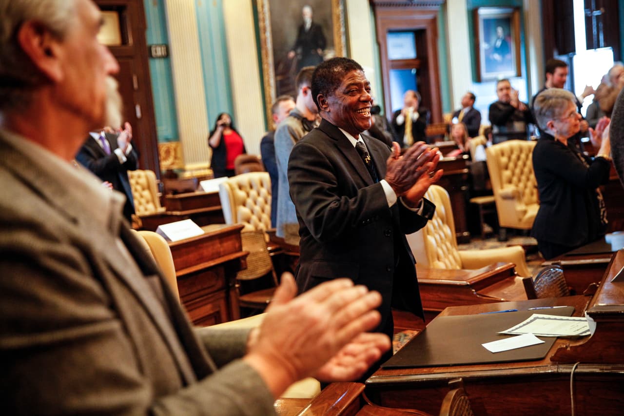 Henry Hatter, representante del Colegio Electoral de Michigan, aplaude luego de ejercer su voto por Donald Trump, en el Capitolio estado de Michigan.