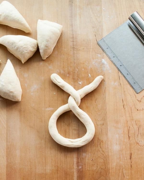 <b>Divide la masa</b> en ocho trozos. Da a cada trozo la forma de bollo redondo y después ovalado. Haz rodar cada óvalo hacia atrás y hacia adelante, desliza los dedos a lo largo de la masa, para formar una tira de unos 40 cm de largo, que tenga en el centro un espesor de 2,5 cm y 5 mm en los extremos. 
<br>
<br>
<br>
<br>
