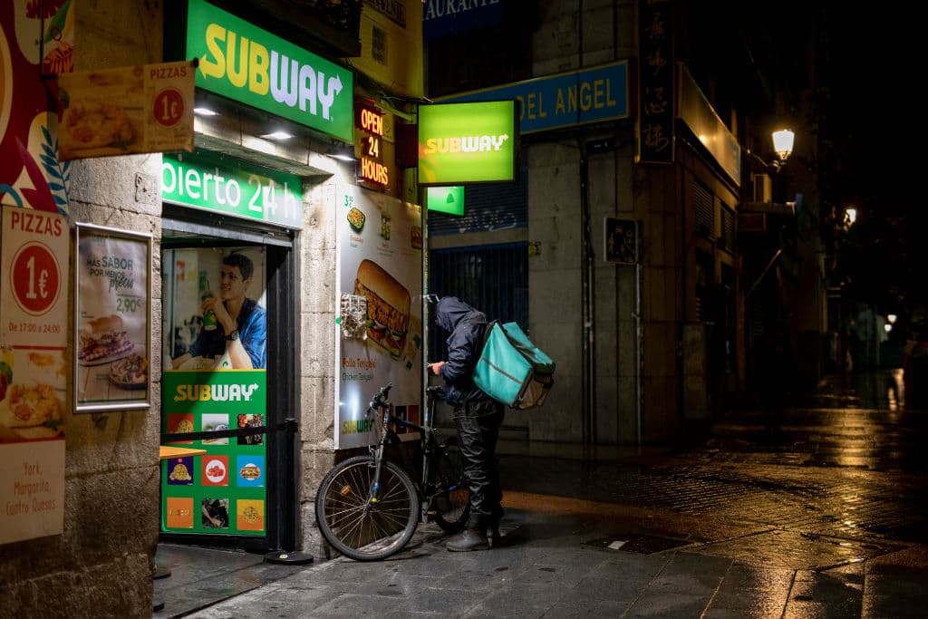 Un solitario repartidor en una calle vacía, poco antes del toque de queda en Madrid, con el que las autoridades intentan aplanar la curva ascendente de casos de covid-19 en España