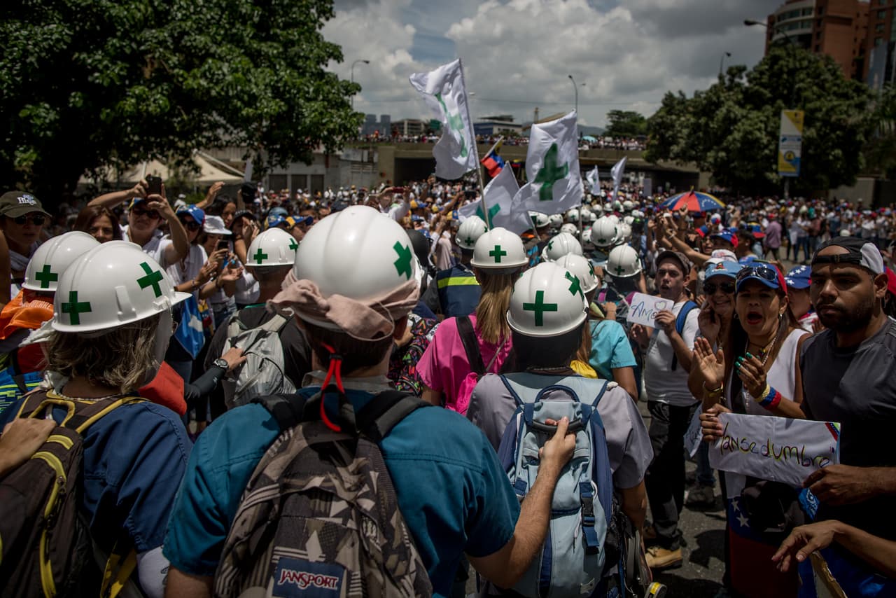 Identified by their white helmets with a painted green cross, the demonstrators make way for them. During clashes they spread out and are assigned colors according to their proximity to the front lines: Red (those in the line of fire), orange (at a prudent distance) and green (further removed to organize transport to medical clinics).