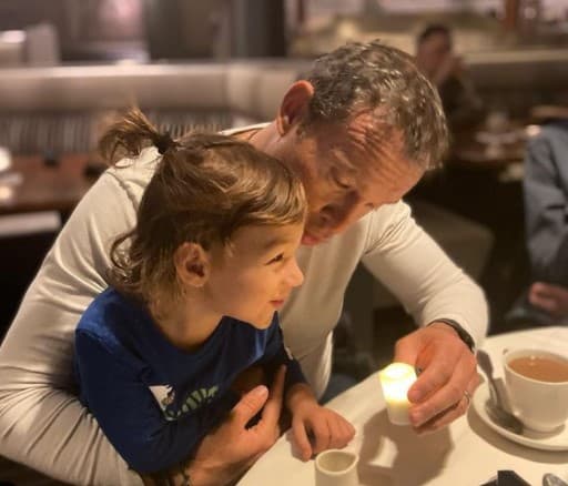 Liam, el más pequeño de la familia, disfruta de la compañía de papá, y podemos ver lo largo que es su cabello.