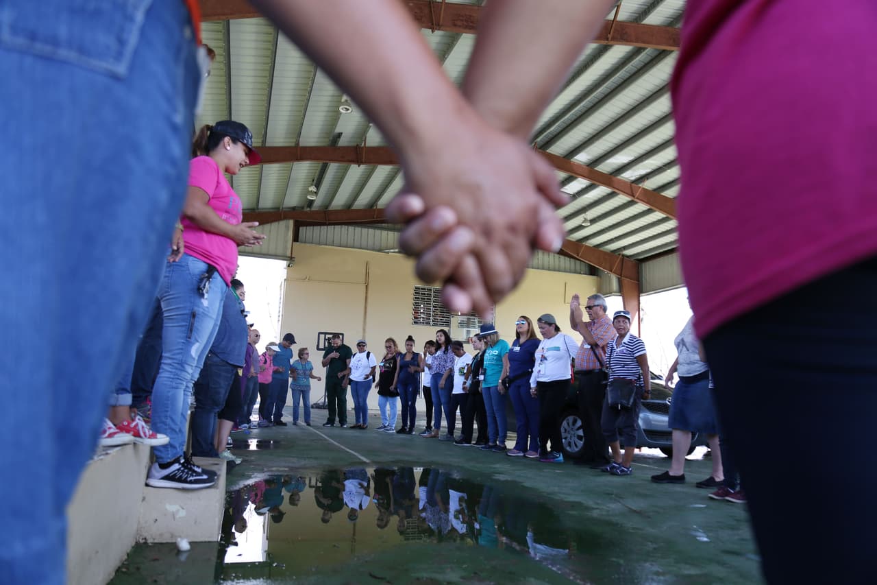 Los voluntarios que asisten a enfermos y afectados por el huracán en Humacao comienza la jornada con una oración en grupo.
<br>