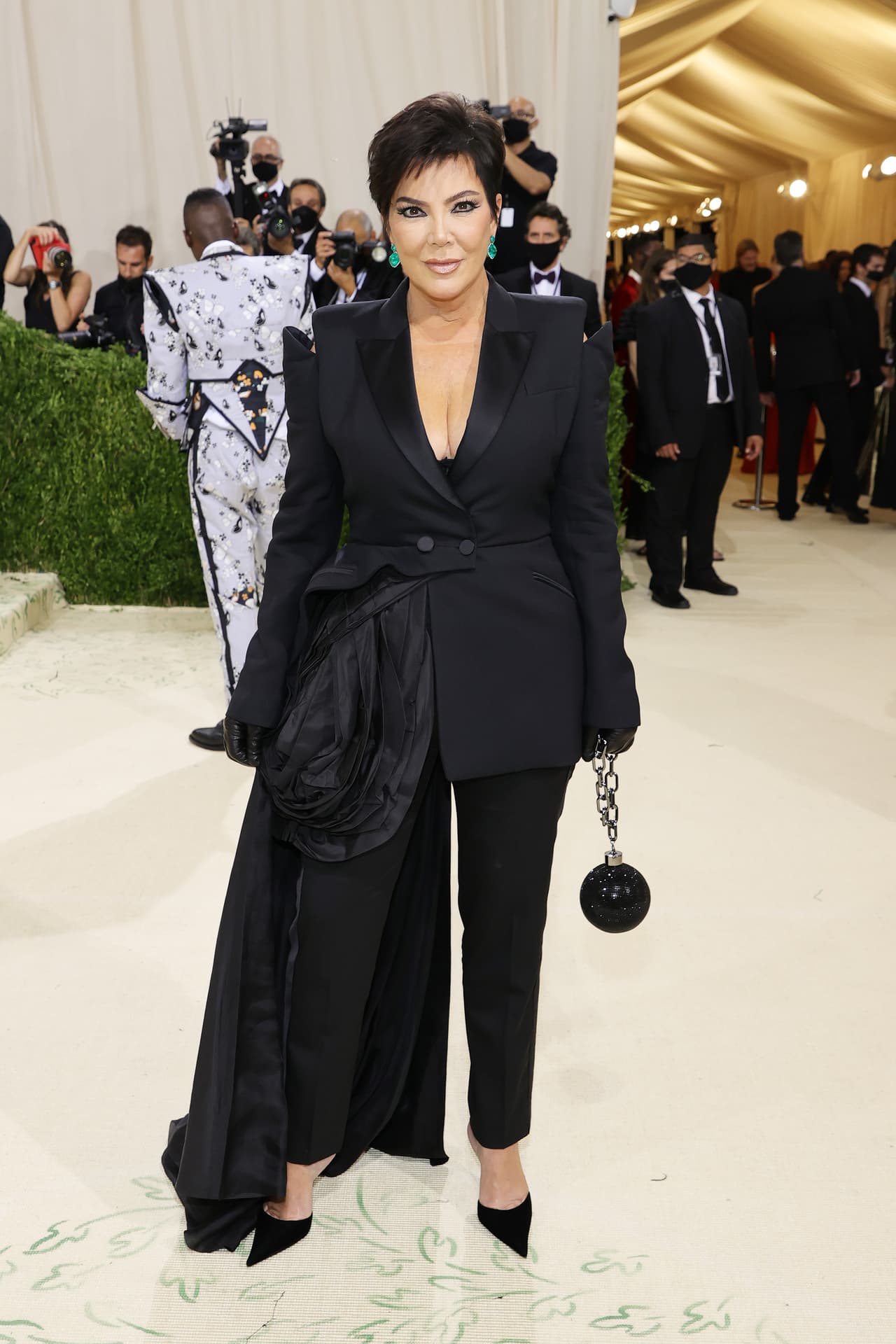 La matriarca de las Kardashian asistió al exclusivo evento con un look de Donatella Versace. 
<b>Kris Jenner</b> también llevó un look monocromático en negro al igual que Kim. En el traje destacó el abrigo con una gran caída y guantes tipo látex.