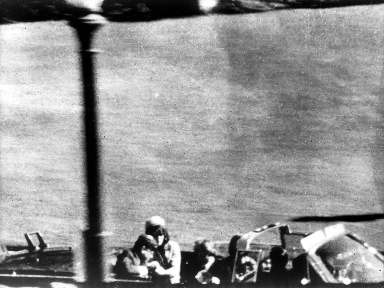 La decisión del presidente John F. Kennedy de recorrer las calles de Dallas en un auto descapotado permitió que fuera un blanco fácil. La Comisión Warren determinó que el asesino conocía el recorrido de la caravana presidencial y planificó la posición perfecta para disparar mortalmente al primer mandatario. La fotografía corresponde al instante después del primer disparo que hirió al presidente.