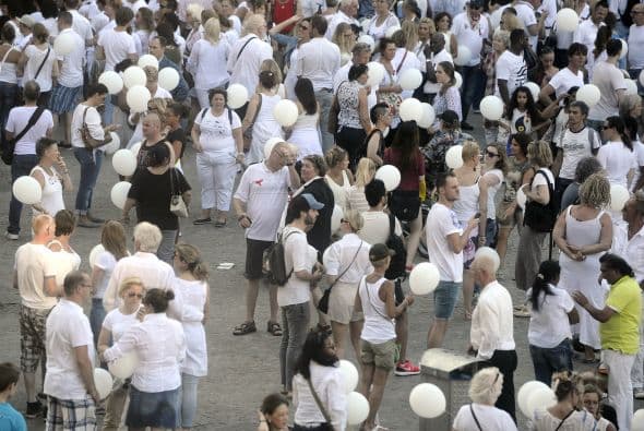 Personas vestidas de blanco se reúnen en la Plaza Dam en Amsterdam durante una marcha del silencio en memoria de las víctimas.