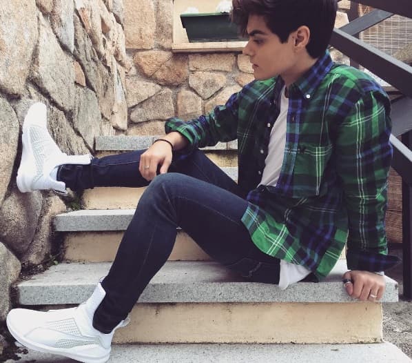 Para estar a la moda Abraham usa jeans skinny en color azul, una camisa a cuadros y zapatillas blancas marca Puma, el look ideal para ir a cualquier lugar.