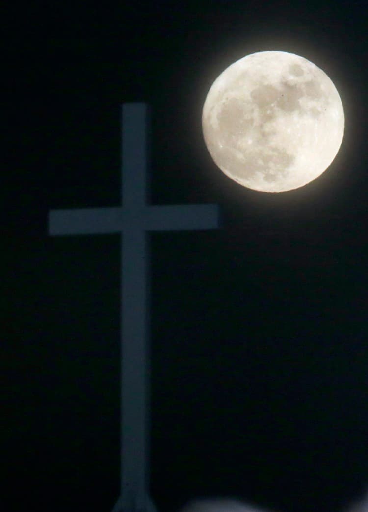 La luna, tras una cruz de una iglesia en Lawrence, (Kansas)