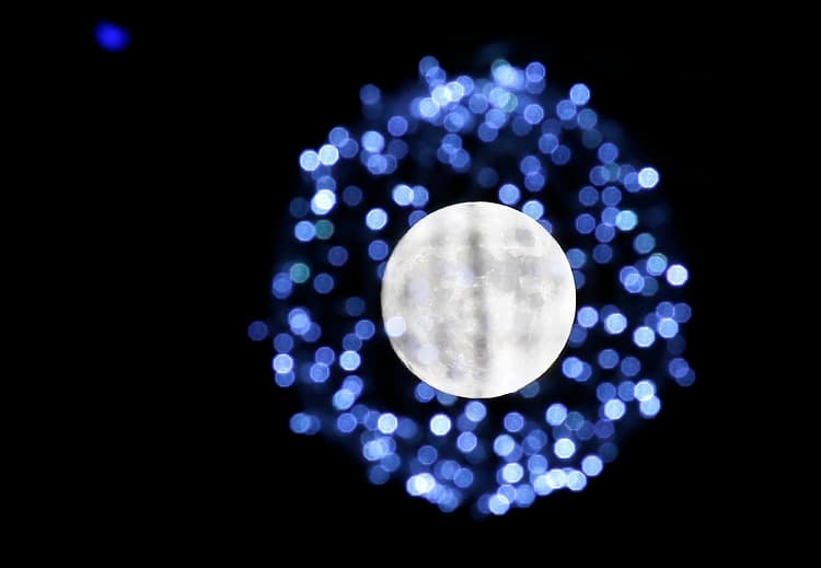 La luna llena tras la decoración navideña en la plaza Oktyabrskaya en Minsk (Bielorrusia)