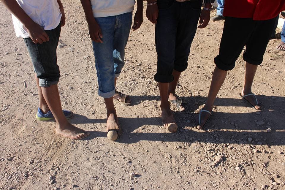 En la "carrera de bola" dos equipos rivales corren mientras sus integrantes patean una esfera de madera.