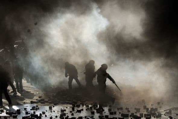 La policía ucraniana cercó hoy a los manifestantes en el corazón de las protestas opositoras de la plaza de la Independencia de Kiev (Maidán), tras una jornada en la que murieron 14 personas en los disturbios que estallaron en la capital. Víktor "Yanukóvich se ha convertido en un presidente sangriento", aseguró hoy el dirigente opositor Vitali Klitschkó en un llamamiento a los países democráticos para que intervengan en Ucrania y frenen la violenta confrontación. Según se acercaba la medianoche, los temidos Berkut, el destacamento antidisturbios, estrechaban el cerco en torno a los miles de manifestantes concentrados en el Euromaidán, bastión de las protestas desde el pasado 21 de noviembre. "Los extremistas de la oposición han cruzado la línea roja; matan a inocentes en la calles de la capital de Ucrania, vejan a mujeres, queman edificios y automóviles. Y si los disturbios continúan, nos veremos obligados a actuar con firmeza", rezaba el ultimátum del Servicio de Seguridad y el Ministerio del Interior de Ucrania. Advierten a los americanos que se queden dentro de las casas y de nuevo se sienten explosiones en la ciudad.