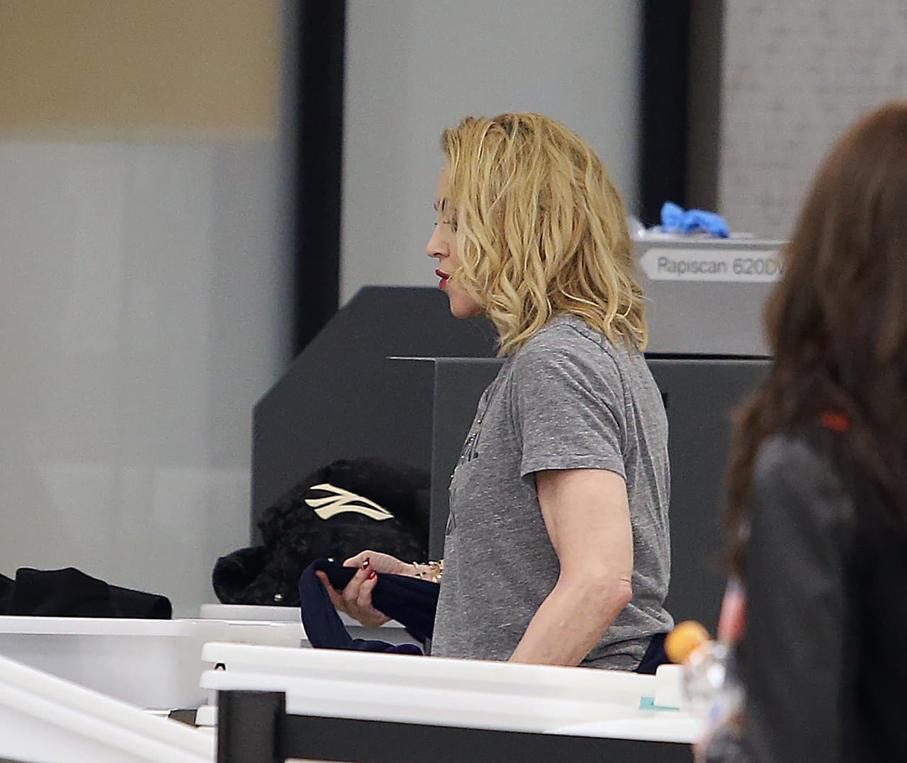 Madonna, quien llevaba el cabello al hombro, caminó por el filtro de seguridad para partir de la ciudad de Nueva York.