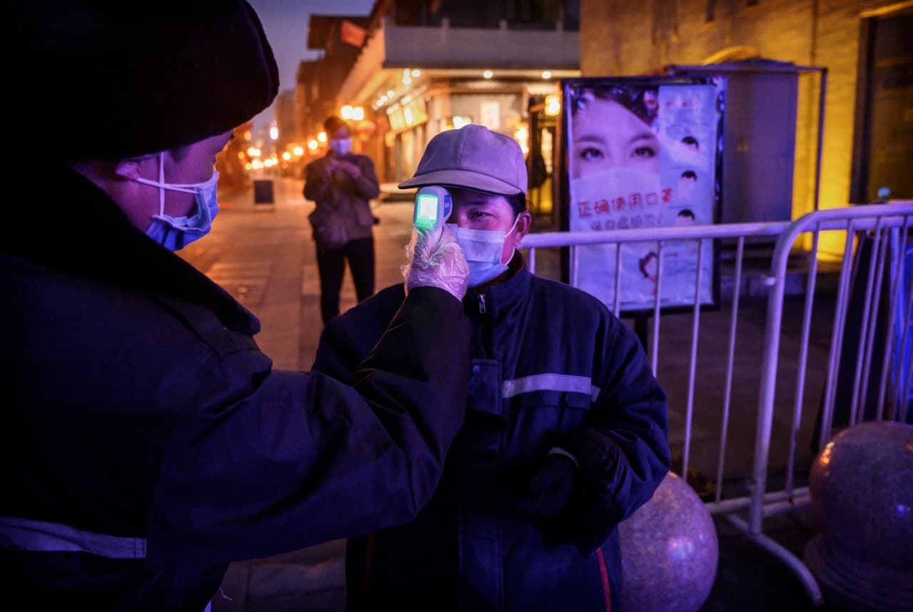 Una trabajadora china es evaluada en un área comercial prácticamente vacía el 12 de febrero del 2020.