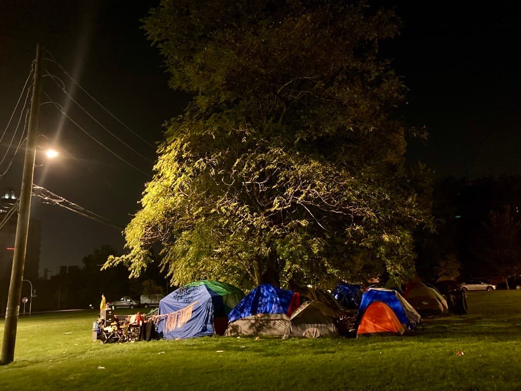 Migrantes arman campamentos y se refugian del frío.