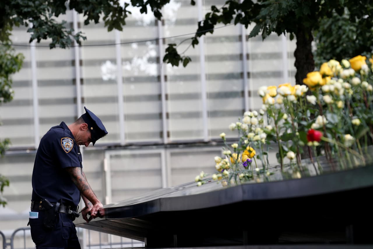 Un agente del Departamento de Policía de la ciudad de Nueva York toma un momento para reflexionar frente a la imponente fuente que conmemora a las víctimas. (Brendan McDermid/Reuters)