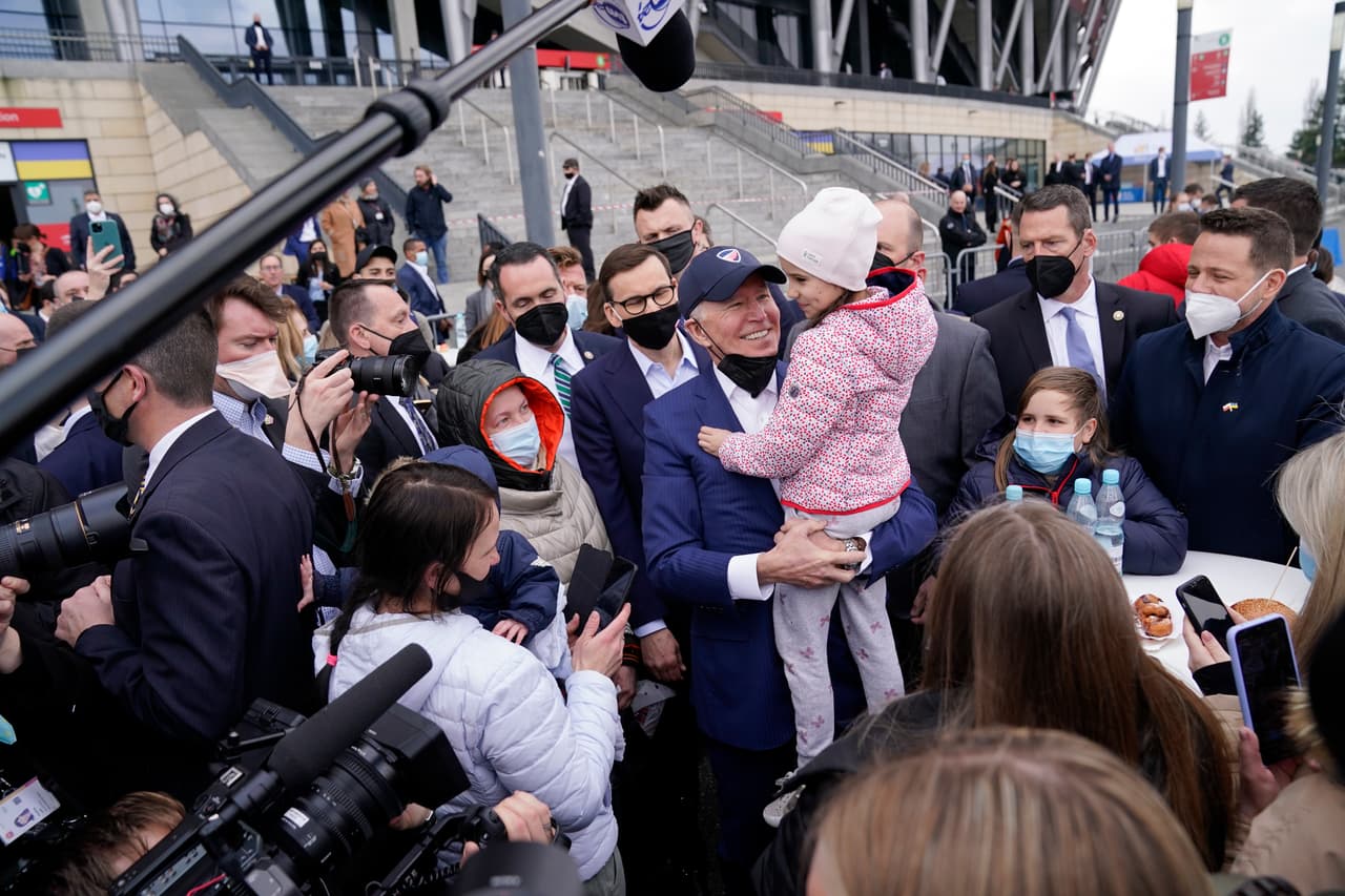 Biden alza a una niña refugiada ucraniana.