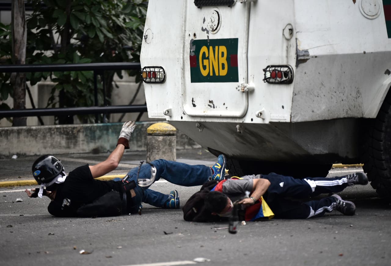 A National Guard armored vehicle rolls over opposition protesters in Caracas. May 3, 2017.