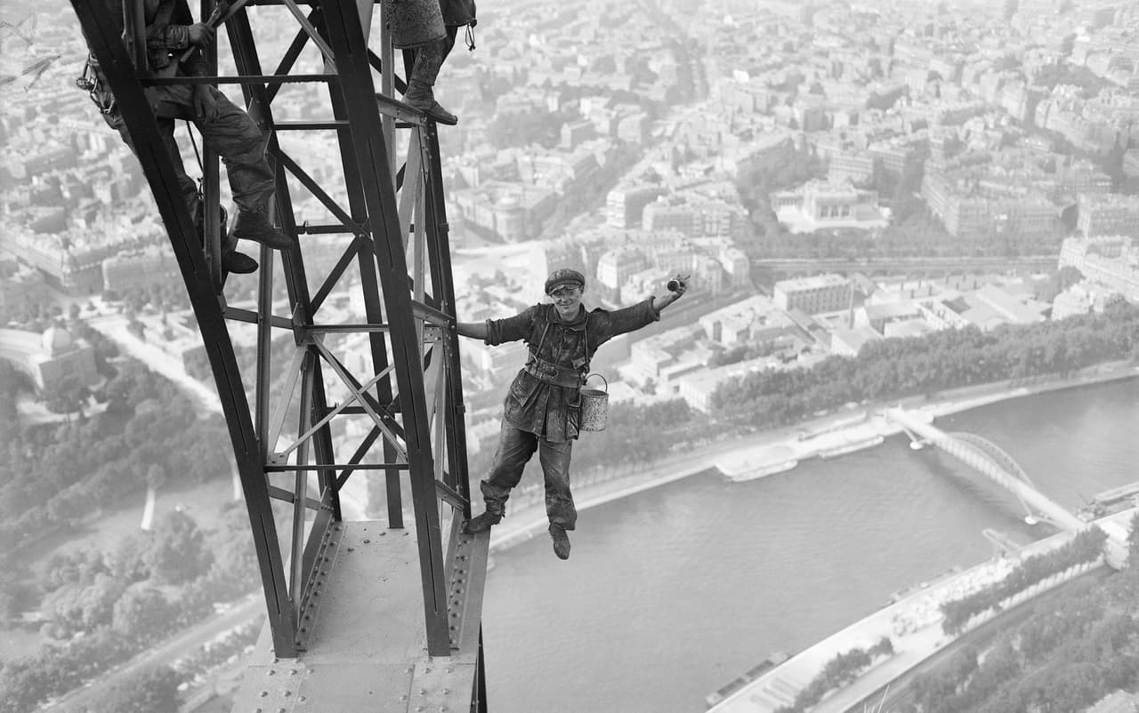 Una foto de 1924 que muestra a obreros trabajando en la Torre Eiffel para volver a pintar la gran estructura de acero. La Torre Eiffel tiene 984 pies de altura y consiste en un armazón de hierro apoyado en cuatro pilares desde donde se alzan cuatro columnas que se unen para formar una sola torre vertical.
<br>