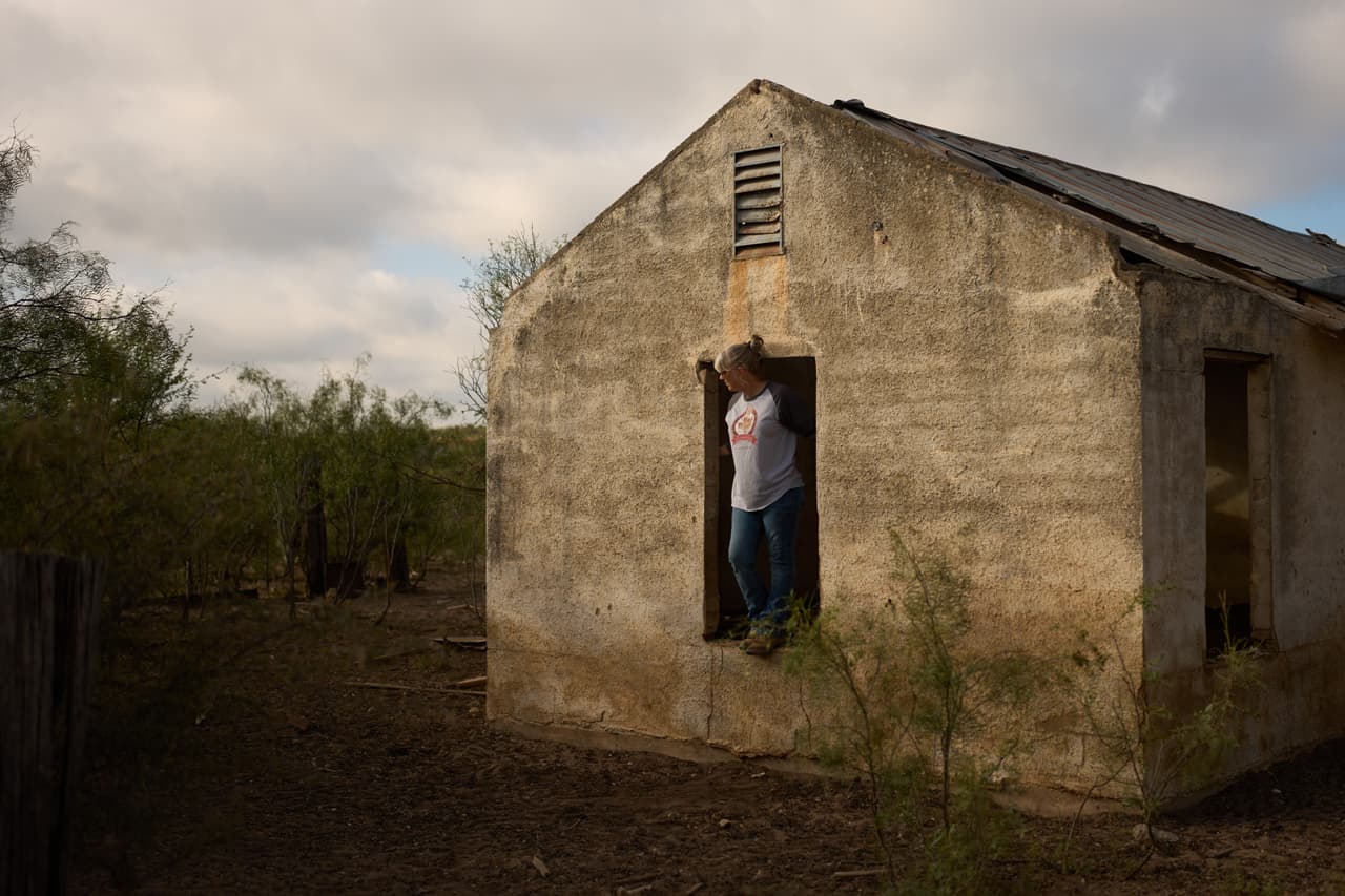 Laura Allen se asoma por la ventana de una antigua casa de campo mientras espera a su esposo en su rancho, el viernes 25 de septiembre de 2026, en Comstock, Texas.