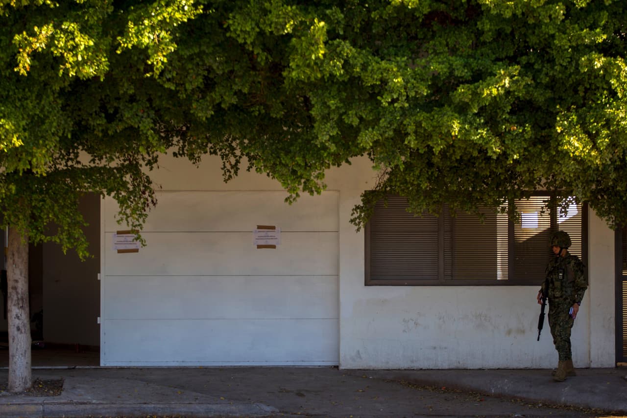 Un infante de la marina hace guardia afuera de la casa de la que "El Chapo" huyó a través del sistema de alcatarillado