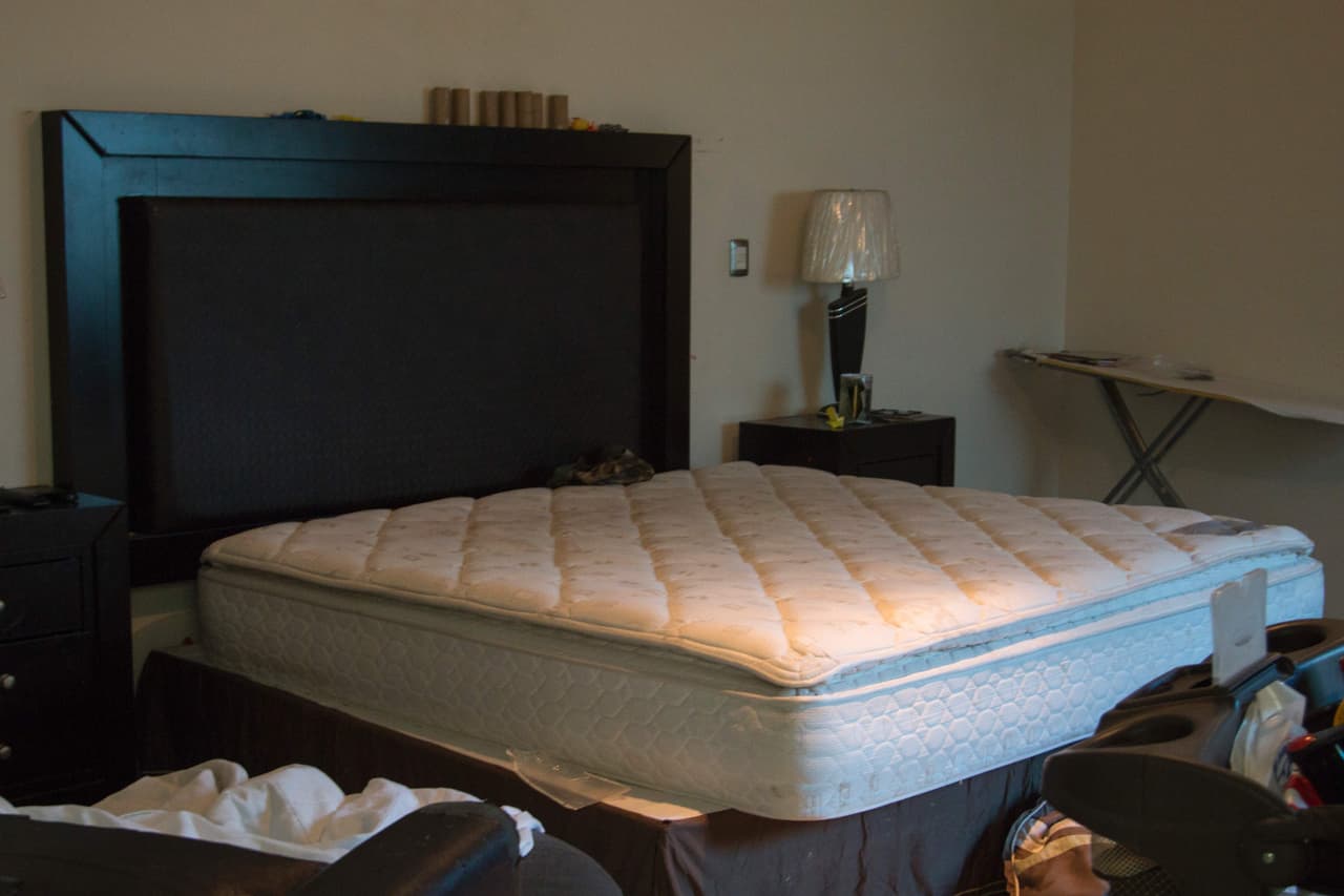 Una de las recámaras de la casa, amueblada con un colchón, una lámpara sin usar y diversos objetos tirados en el piso.