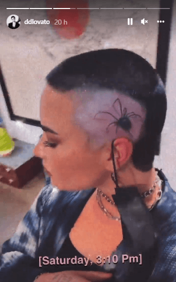 Lleva ahora una gran araña negra en el costado de su cabeza recién afeitada.