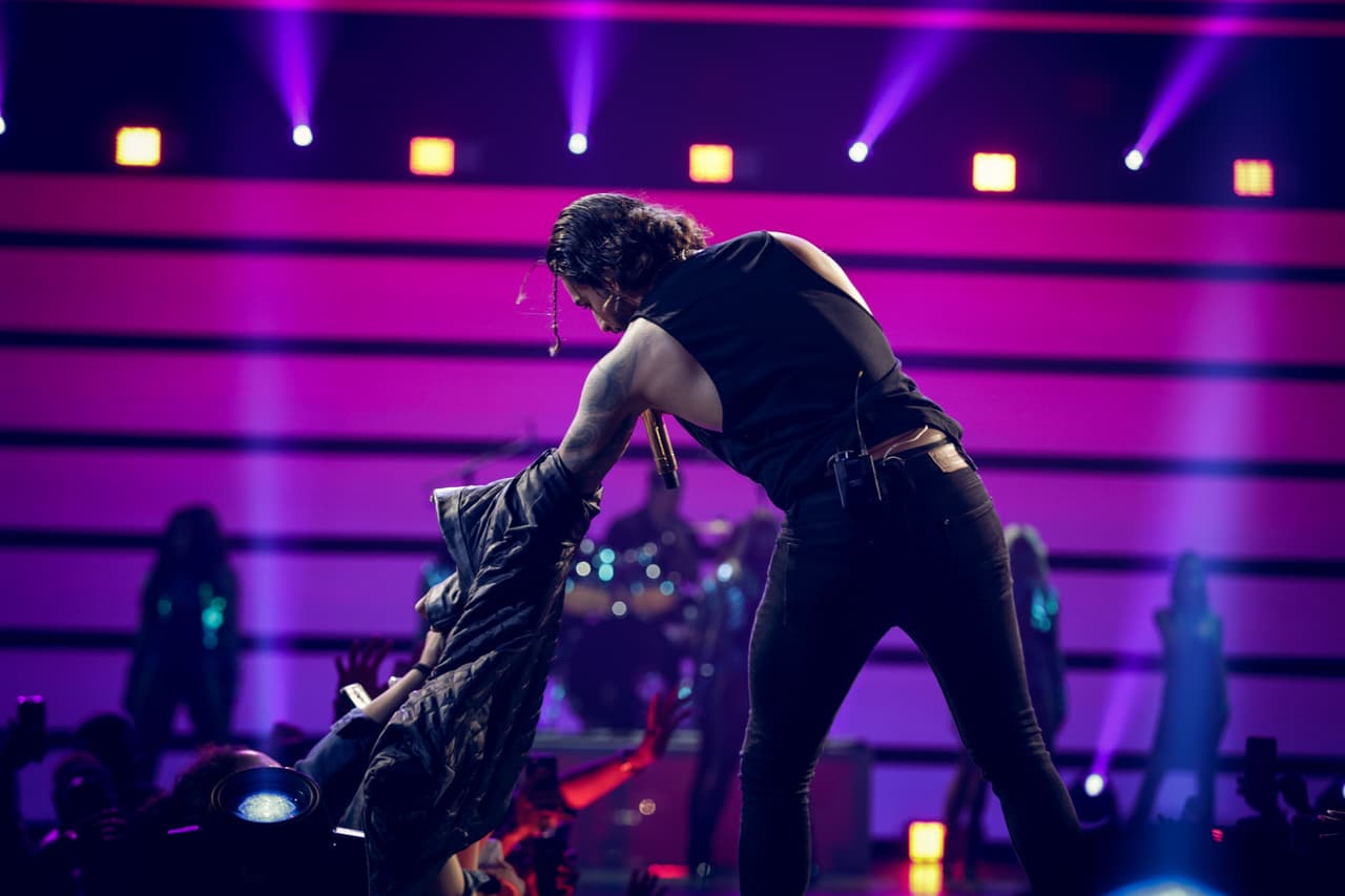 Despojarse de la prenda se puso complicado, por lo que el cantante se acercó a su público para que lo ayudara, pero entonces ocurrió un malentendido.