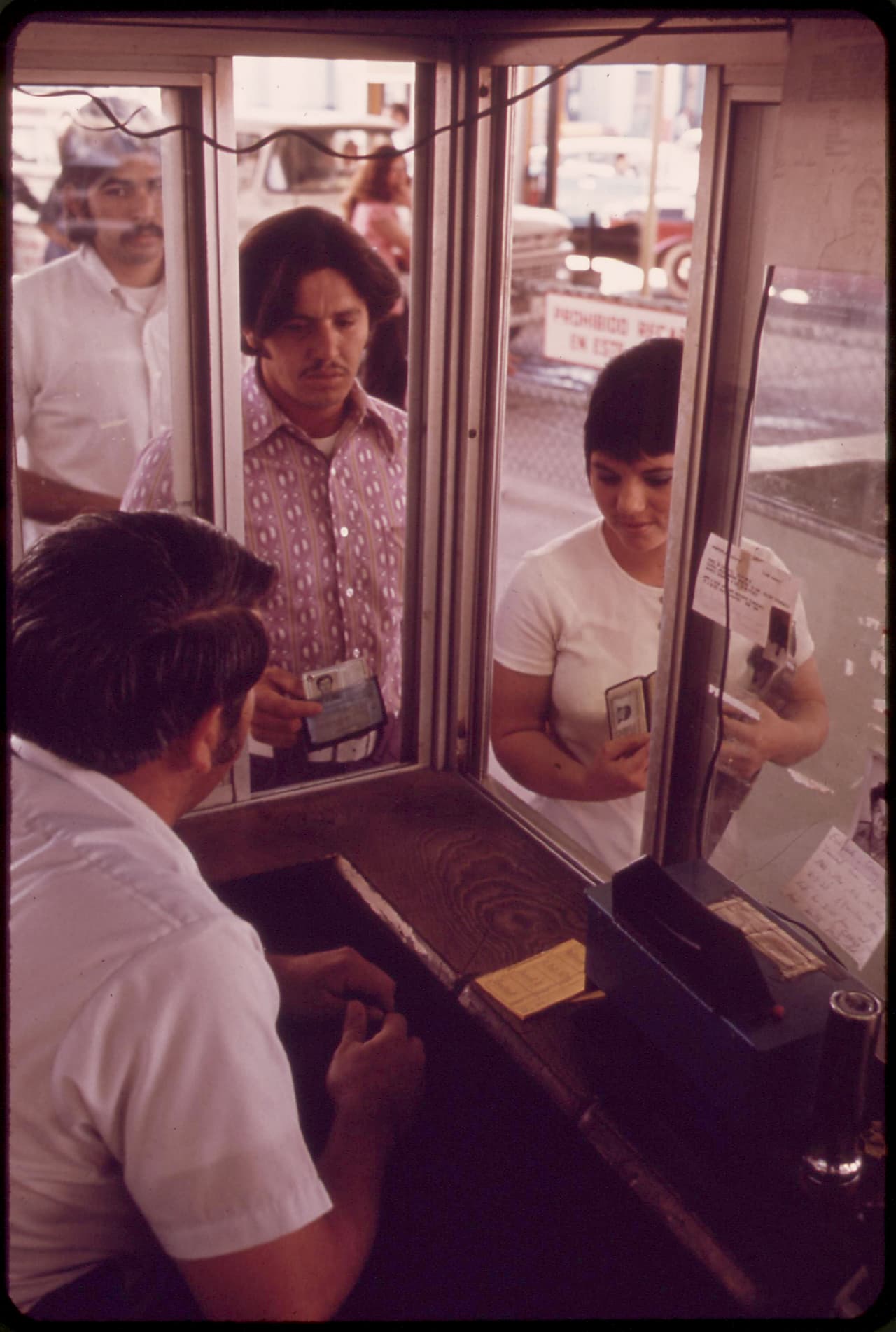El agricultor Hugo Olivas y su esposa muestran sus Green Card en la frontera para entrar a Estados Unidos, donde trabajan y hacen sus compras. Calexico, México. Abril de 1973.